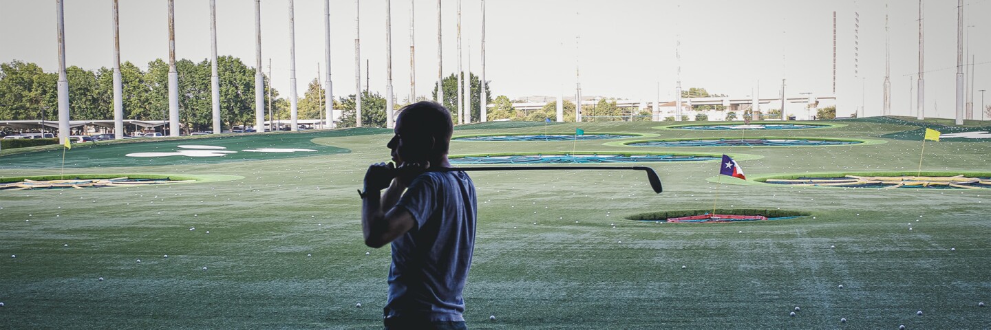 man post swing at a topgolf event. 