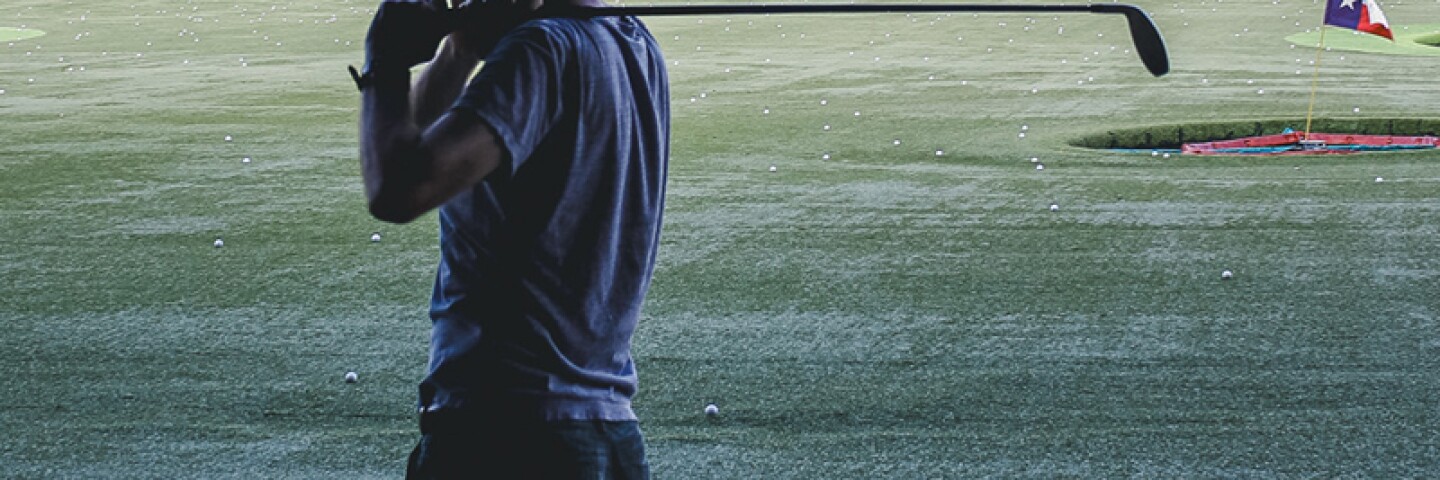 man post swing at a topgolf event. 