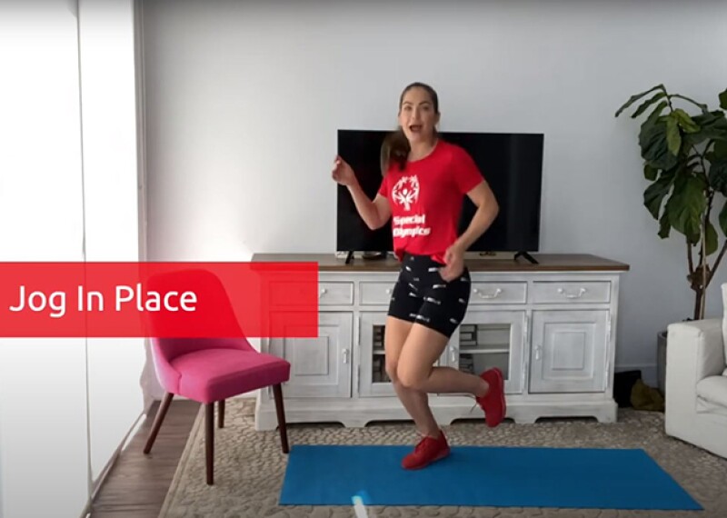 Shannon Decker jogging in place in her living room for a workout video. 