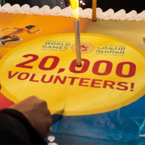 A cake that has a candle that reads 20,000 volunteers