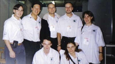 Seven people wearing white jerseys posing for the photo.