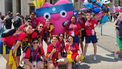 Group of women wearing Spanish outfit pose for a picture in front of the Brandenburg Gate in Berlin