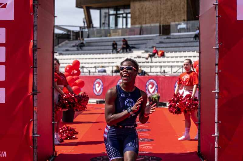 Special Olympics athlete smiling while crossing the finish line