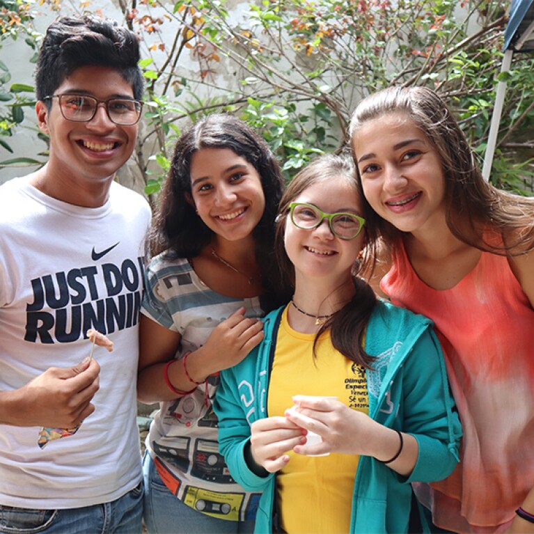 Four young adults standing together for a group photo. 