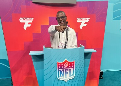 Man standing behind a NFL podium speaking. 