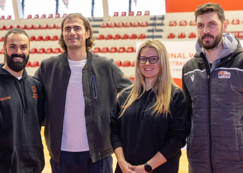 Four people, three men and one woman, standing and posing for the photo