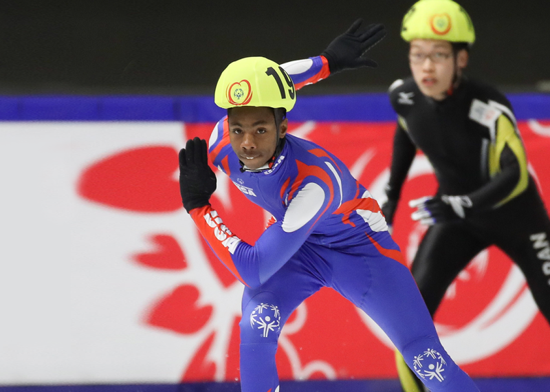 A Special Olympics USA speed skater races during the 2017 Special Olympics World Games in Austria as a competitor from Japan looks on.