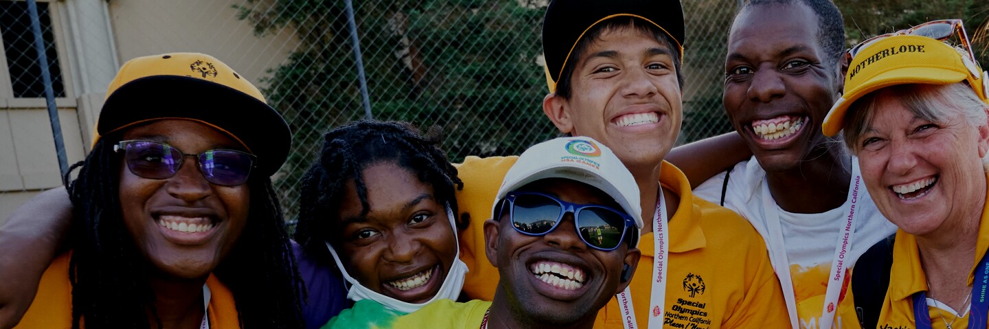 6 people smiling and in a group together. 