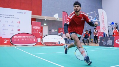 Man playing badminton and running for the birdie. 