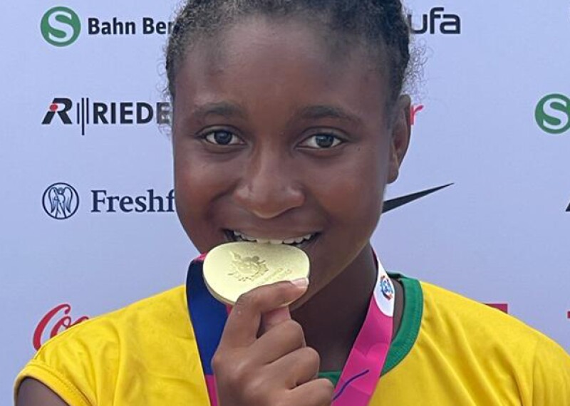 Young woman biting her gold medal. 