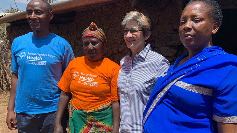 Four adults standing shoulder to shoulder for a group photo. 