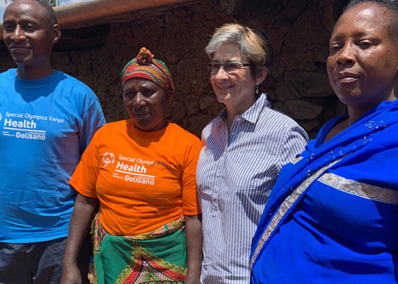 Four adults standing shoulder to shoulder for a group photo. 