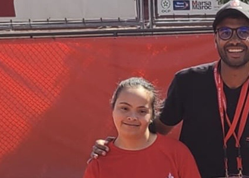 Young man and woman standing next to one another on the tennis court. 