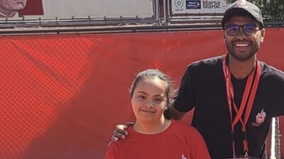 Young man and woman standing next to one another on the tennis court. 