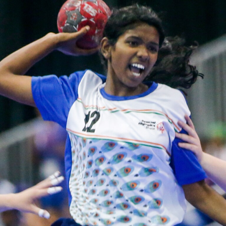 Three young women playing a game of handball. 