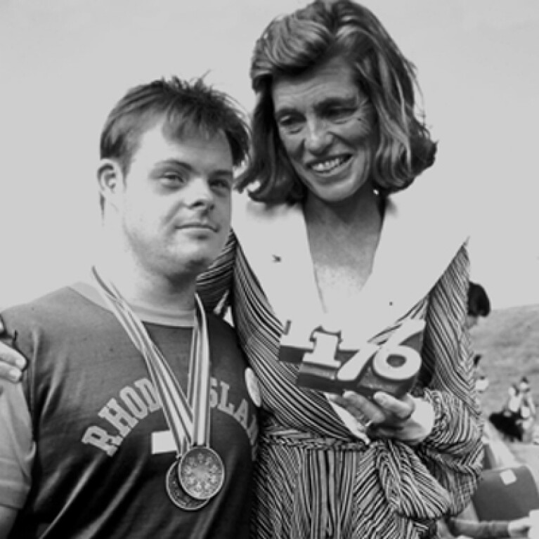 Eunice Kennedy Shriver standing next to athlete. 