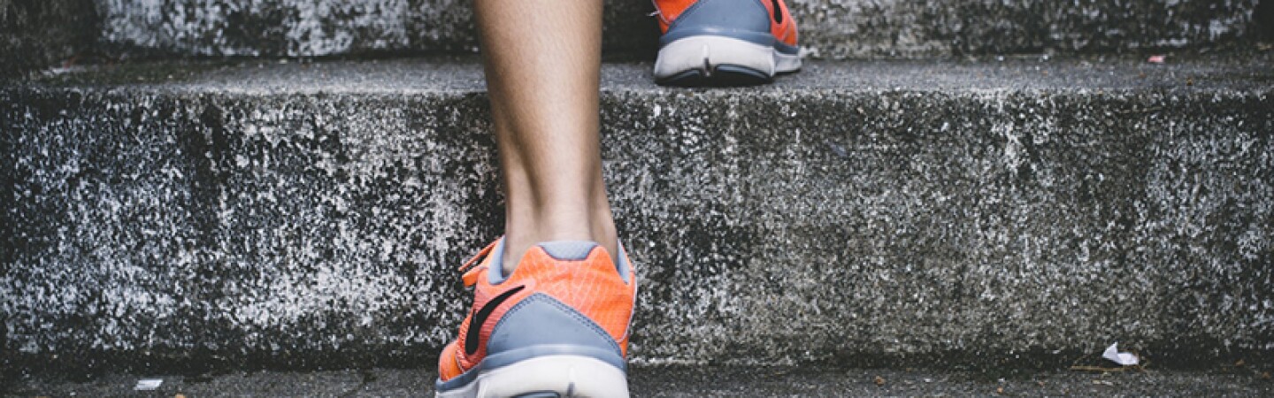 Young persons walking up stone steps in Nike sneakers. 