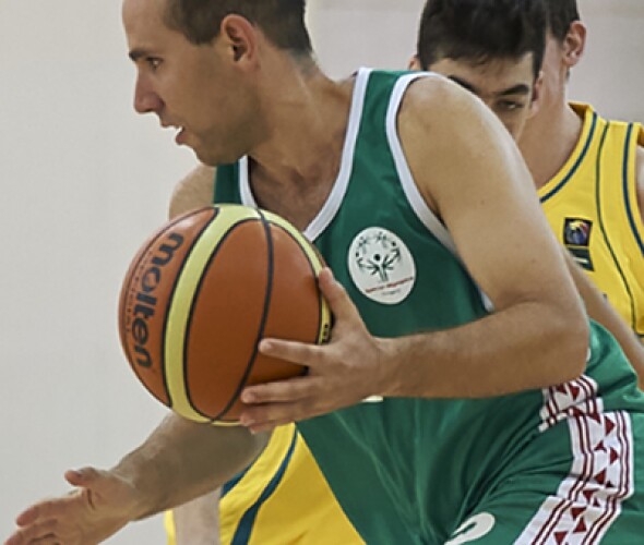 Man dribbling the ball and two members from the opposing team are trying to steal it. 