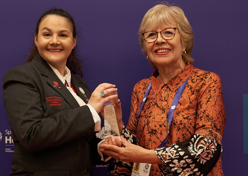 Young woman presenting another woman with an award. 