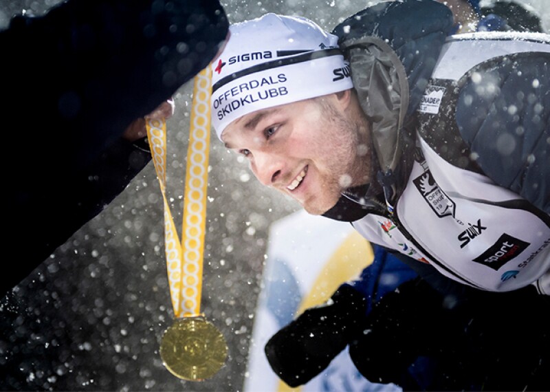 Athlete receiving gold medal and it's snowing. 