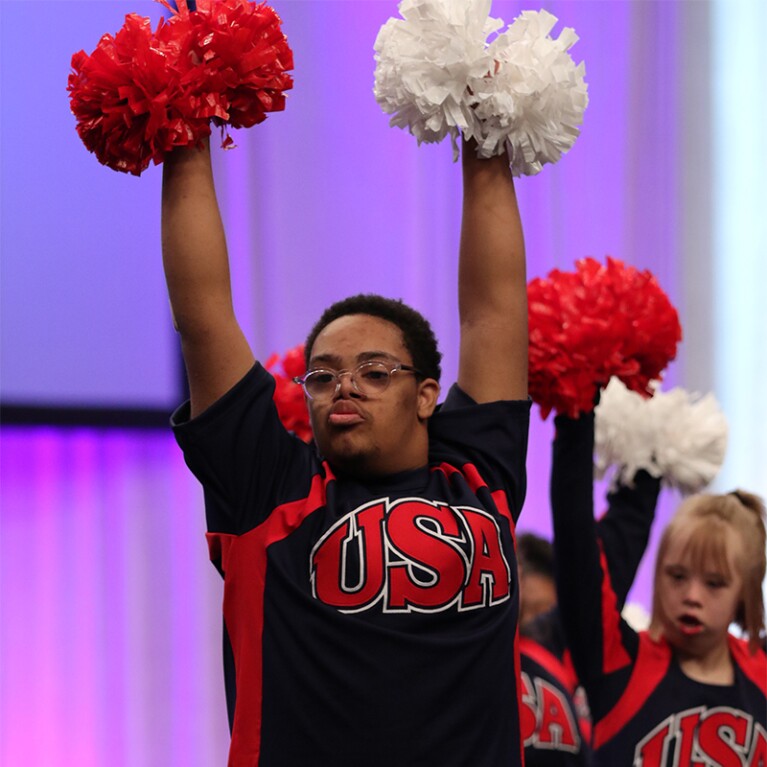 Male cheerleader cheering with the squad.